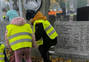 Dzieci stawiają znicze na grobie nieznanego żołnierza