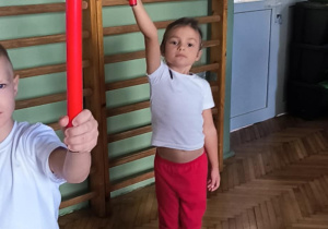 Dziewczynka trzyma w górze laskę jedą ręką