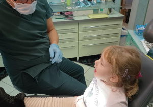 Dziewczynka siedzi na fotelu dentystycznym