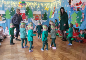 Dziec istoją w kole i wystawiają naprzemian nogi do przodu
