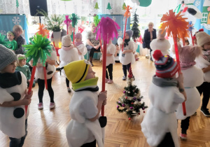 Dzieci obracają się z miotełkami