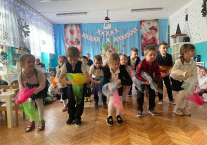 Dzieci z grupy czwartek stoją w rzędach i tańczą