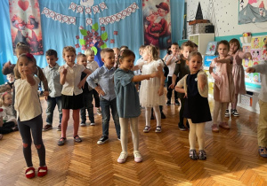 Dzieci wskazuja palcami na dziadków