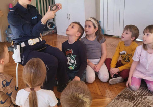 dzieci siedzą podczas rozmowy z policjantką