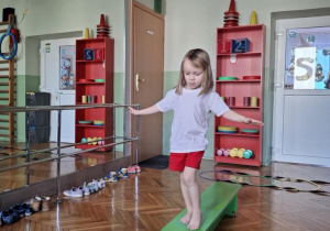 dziewczynka idzie po ławeczce