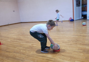 Chłopiec odklada pilkę do ragby