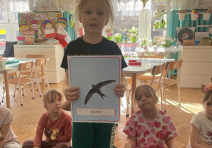 Chłopiec stoi z planszą ptaka jerzyka