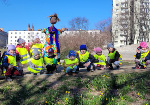 dzieci podziwiają pirwsze wiosenne kwiaty