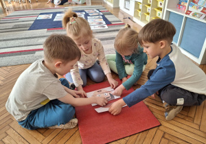 Grupa dzieci układa puzze z emocjami