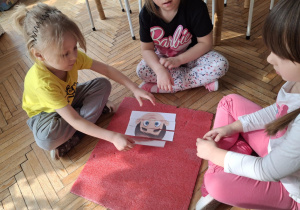 Dzieci na macie układają puzzle z emocjami