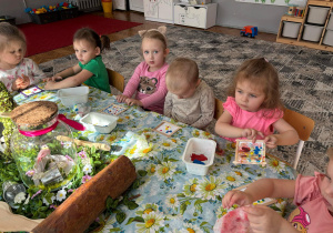 Dzieci siedzą przy stole z kolorowymi ramkami