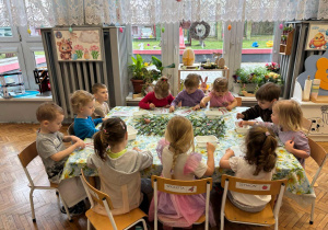 Dzieci siedzą przy stole i pracują