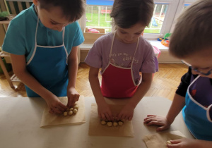 Dzieci robią kulki z ciasta drożdżowego
