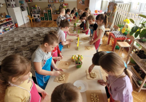 Dzieci kładą kulki na papierze do pieczenia i firmułuja baranka wielkanocnego