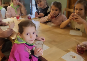 dzieci siedza przy stolikach podczas poczęstunku