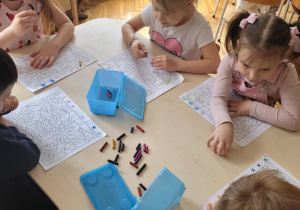 Dzieci przy stoliku wykonują kodowanie