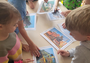 Dzieci oglądają ilustracje różnych pociągów