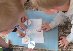 Dzieci przykładają pojazdy wodne do ilustracji morza