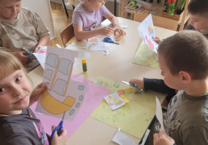 Dzieci wycinają nożyczkami przy stoliku