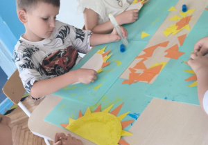 Dziewczynka siedzi z pomalowanym talerzykiem na kolor żółty