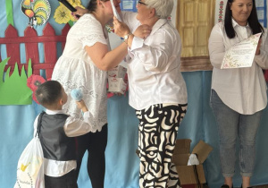 Dyrektor wręcza podzęikownaie mamie z grupy czwartej