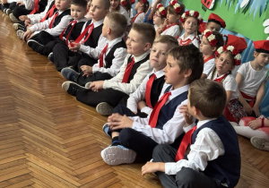 Chłopcy siedzą w jednym rzędzie