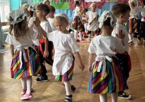 Dzieci tańczą w parze trzymając się za prawe dłonie