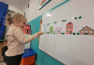 Dziewczynka przelicza okna w fioletowym domu