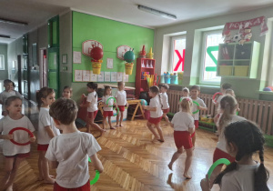 Dzieci stoją po obwodzie koła z malymi kółkami