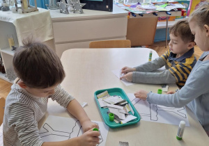 Chłopiec nakleja kawałki gazet
