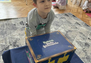 Chłopiec wyciąga ilustrację z magicznego pudełka