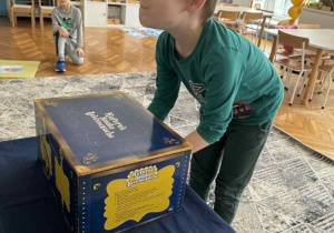 Chlopiec wkalda ręce do magicznego pudełka