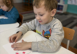 Chłopiec nakleja kolorowy papier na łyżwy