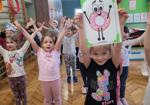 Dziewczynka pokazuje sylwetę pączka w pozie do ćwiczeń