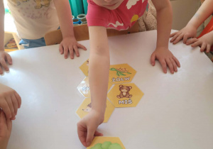 Dziewczynka układa dwusylabowy plaster miodu