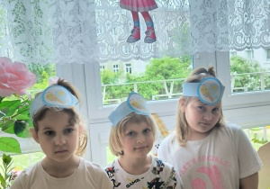 Dzieci stoją z opaskami na głowie