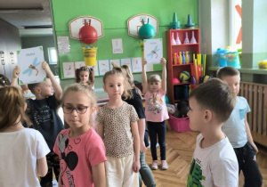Dzieci stoją na sali gimnastycznej
