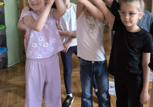 Dzieci trzymają rysunek pająka
