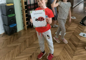 Chłopiec trzyma obrazek biedronki