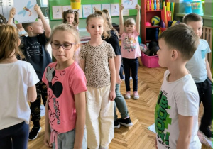 Dzieci stoją na sali gimnastycznej