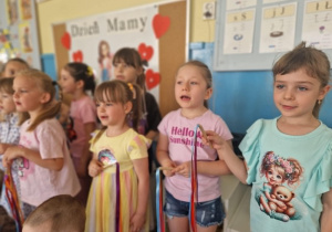 Dziewczynki śpiewają pisoenkę o mamie z kolorowymi wstążkami