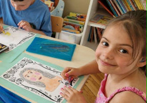 Dziewczynka rysuje portret mamy