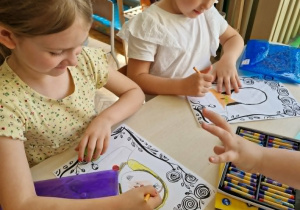 Dwie dziewczynki rysują portret swoich mam