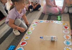 Dziewczynka kręci butelką na planszy