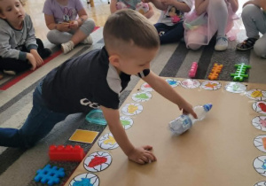 Chłopiec kręci butelką na planszy