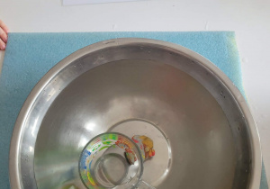 Zatopione w misce z wodą przedmioty - plastelina i kubek