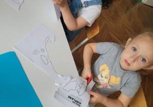 Dziewczynki wycinają samolot na karcie pracy