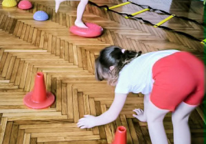 Dziewczynka robi slalom między pachołkami