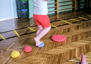 Dziewczynka przechodzi po jeżykach sensorycznych