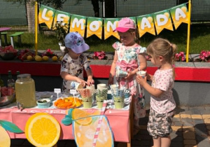 Dzieci rozkladają kubki w sklepiku lemoniady